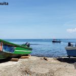 harbor in cahuita displaying boats bathing in the sun and the open sea in the background