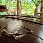 table showing chocolate spread out in a marbel table for the tempering process to prevent it from melting under the caribbean heat