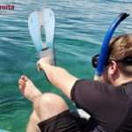 man putting on his equipment and getting ready to jump into water to enjoy the coral reef in Cahuita National Park.